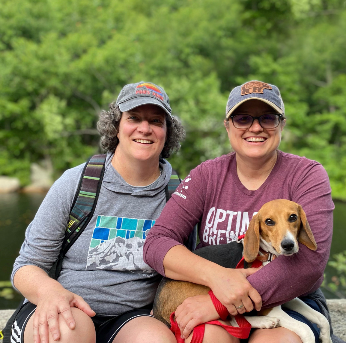 Butter the beagle sitting with two women outside