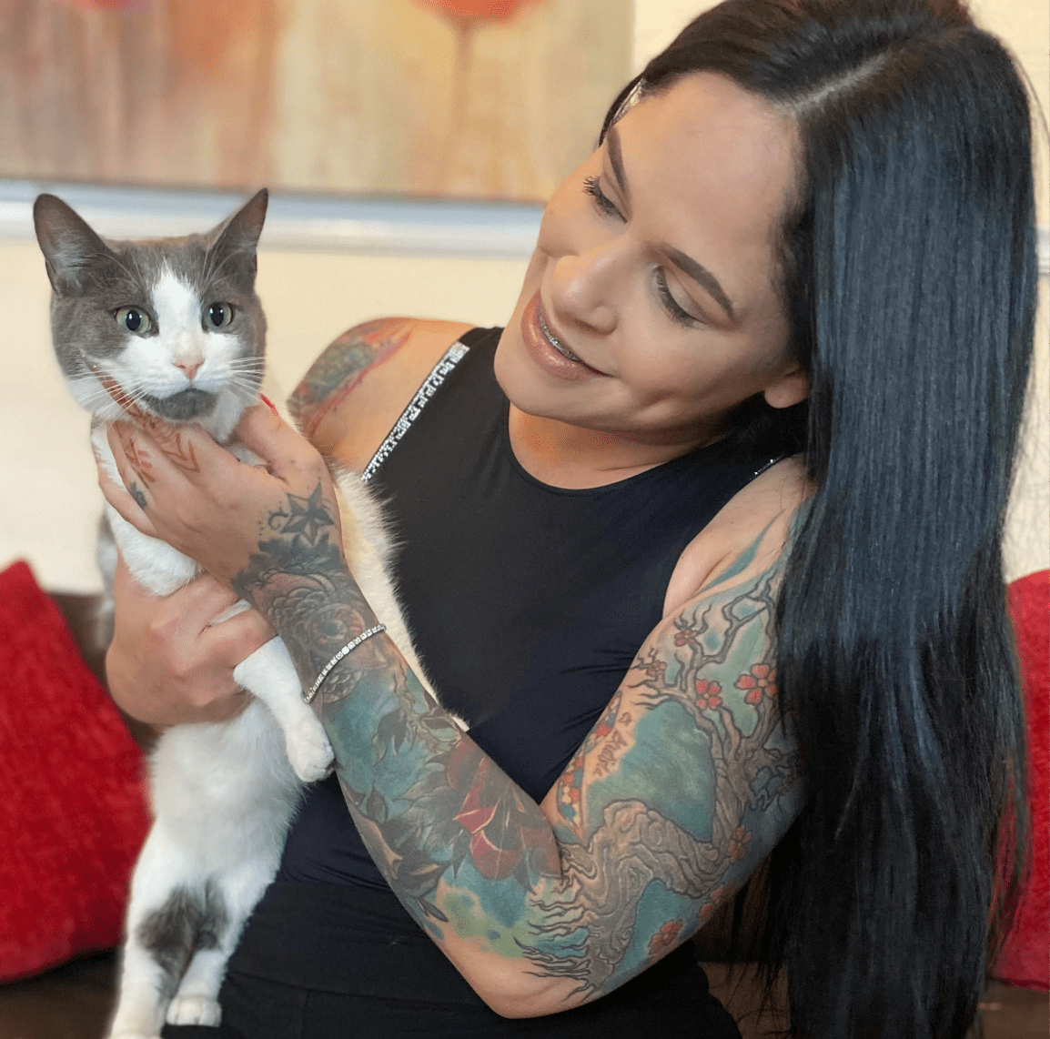 Edmarie cuddles one of a white and gray kitten